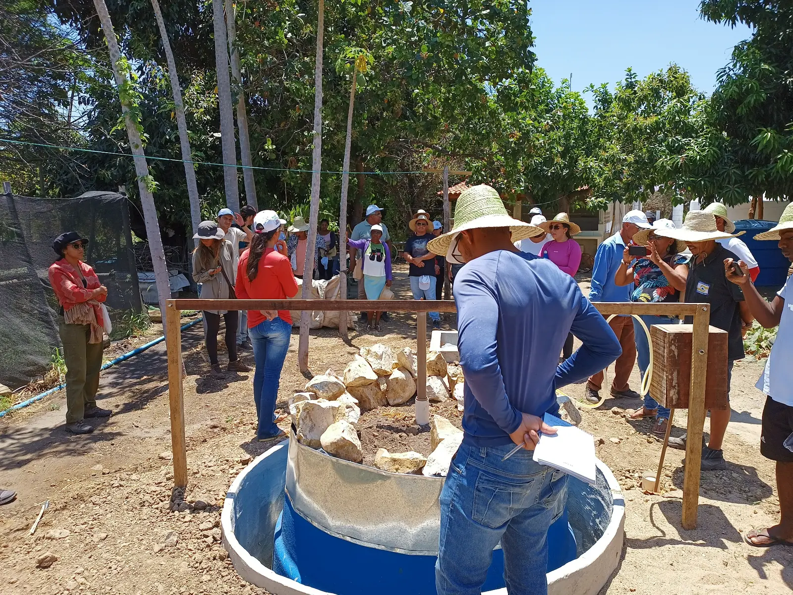 Grupo observa uma estrutura preenchida com pedras durante a visita técnica